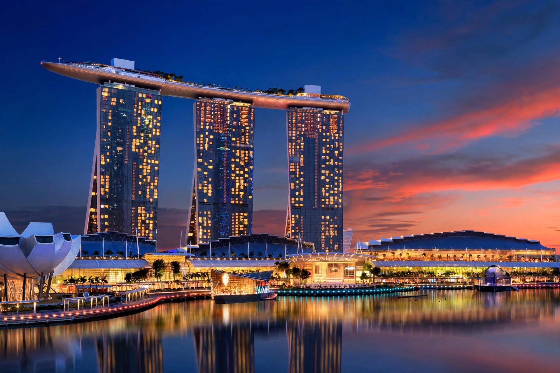 Iconic Marina Bay Sands three towers and cantilevered SkyPark illuminated at sunset